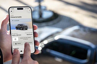 Celular mostrando o app FordPass Connect com o Ranger Raptor em segundo plano